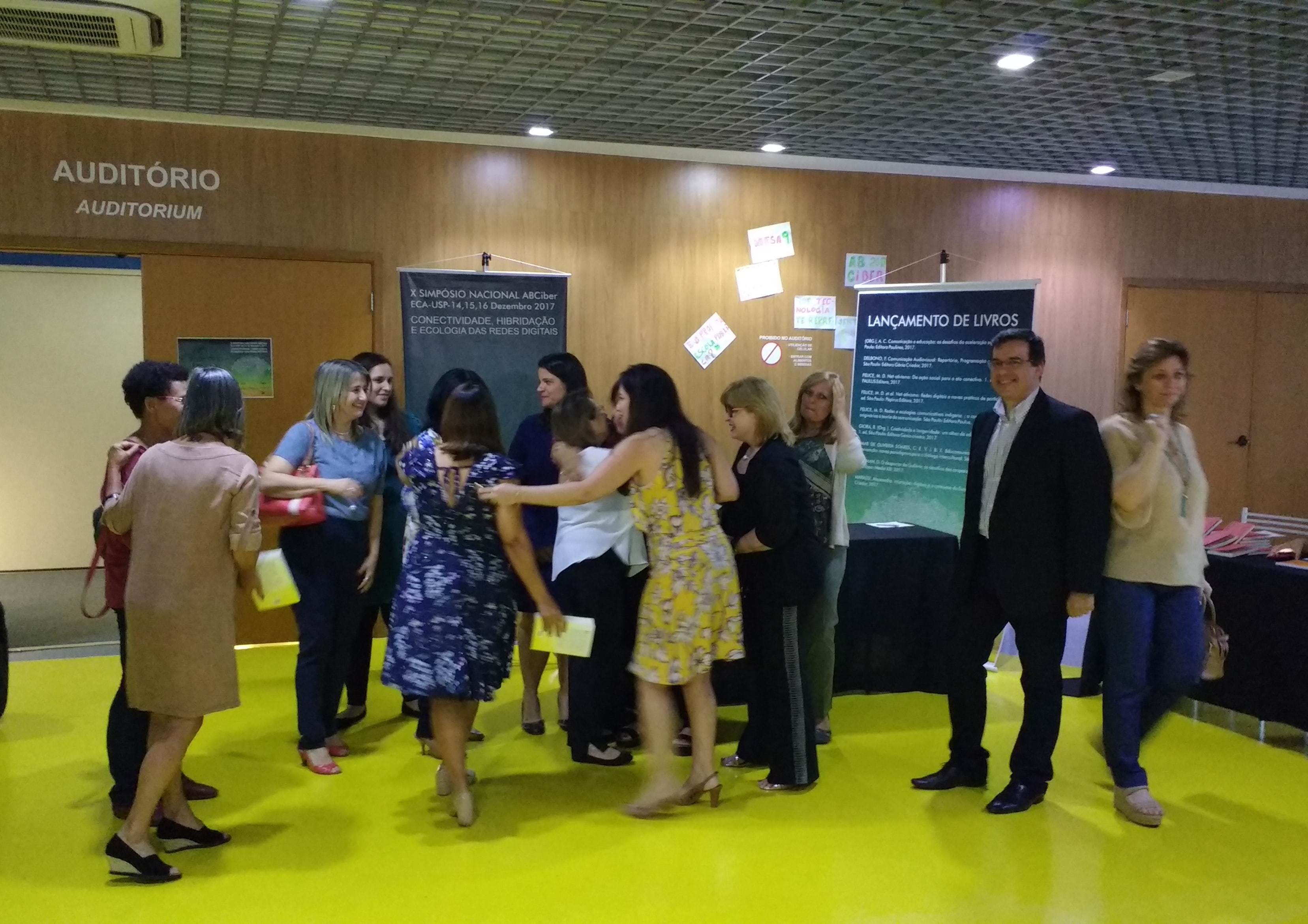 Autores se abraçam após o discurso de lançamento de Regina Célia Giora