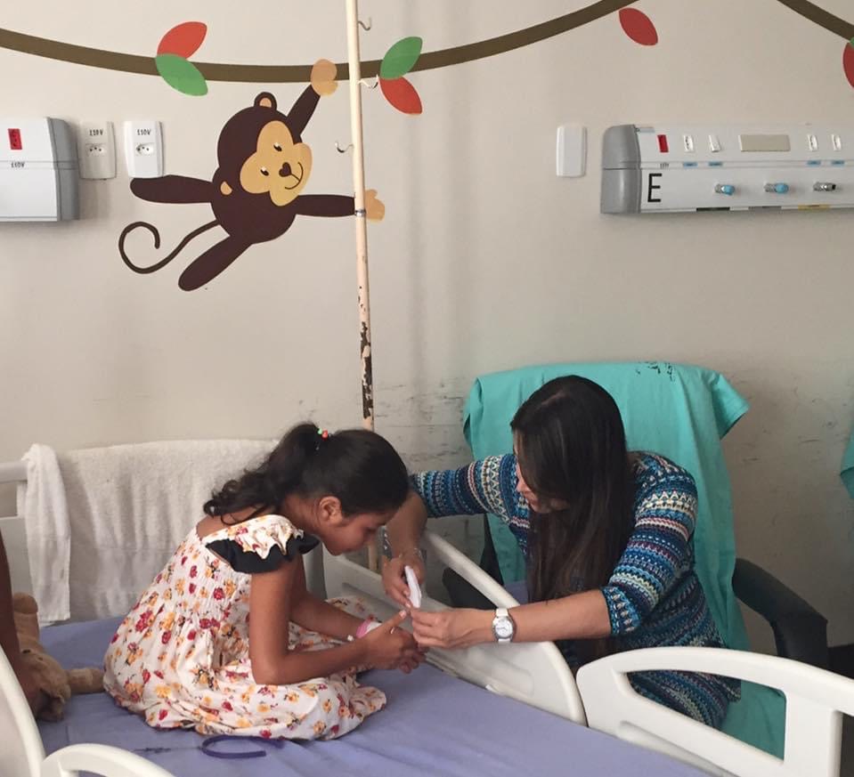 A autora ensina uma paciente a montar um tsuru em um hospital em Campo Grande (MS)